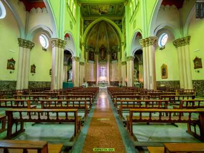 Varchiamo l�ingresso e ci ritroviamo davanti a tre navate scandite da nove colonne sui cui capitelli sono impostati archi a pieno centro. Lo spazio � un po� buio e la poca luce che filtra dal variopinto rosone trasforma il color oro delle pareti in un verde pallido